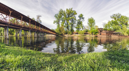 Fototapeta premium Wooden pedestrian bridge over river in Kolarovo, Slovakia