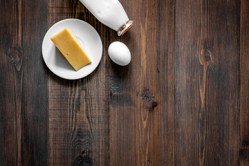 Non GMO, prservatives-free organic food. Milk, cheese, eggs on dark wooden background top view copyspace