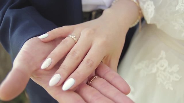 The bride's hand strokes the groom's hand