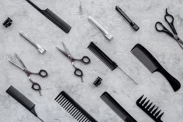 Pattern of combs and hairdresser tools on grey table background top view