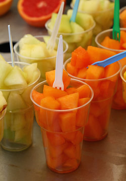 Fruit salad of fresh melon cubes in plastic cups