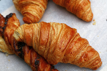Freshly baked golden croissants close up