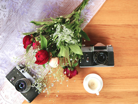 vintage camera near a bouquet of flowers and candles