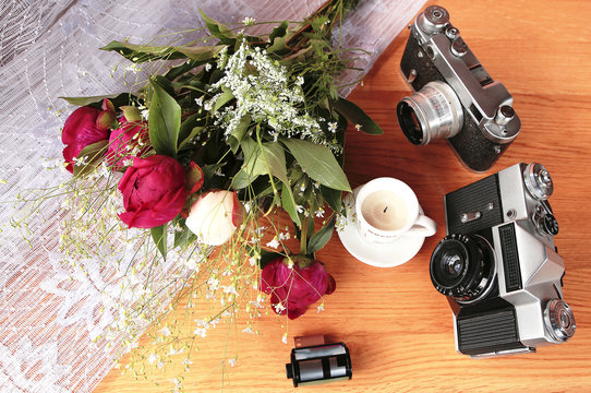 vintage camera near  of flowers and candles