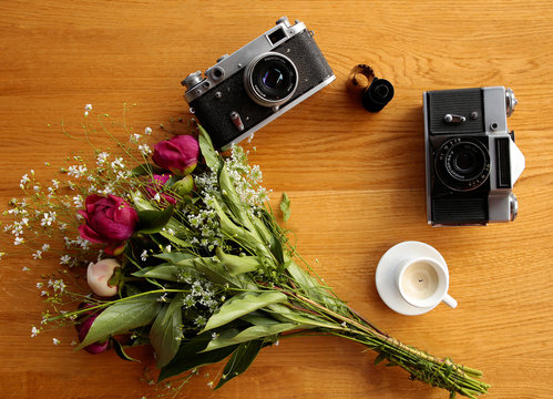 vintage camera near a bouquet of flowers and candles