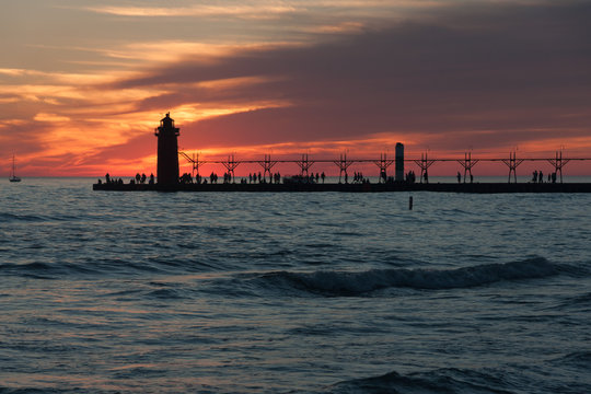 Dramatic photo of lighthouse and pier at sunset.
