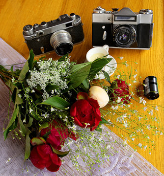 vintage camera near a bouquet of flowers and candles