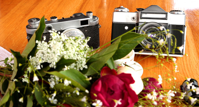 vintage camera near a bouquet of flowers and candles