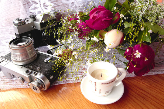 vintage camera near a bouquet of flowers and candles