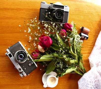 vintage camera near a bouquet of flowers and candles