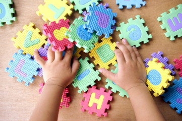 A kid's hands playing with alphabets toy
