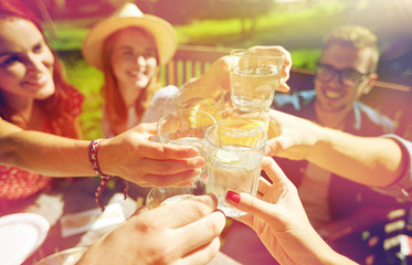 happy friends with drinks at summer garden party