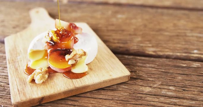 Cheese topped with walnut, fruits and sauce