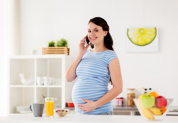 Obraz na płótnie Canvas happy pregnant woman calling on smartphone at home