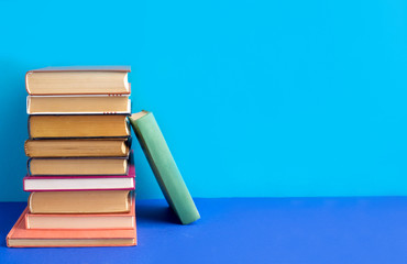 Books stacked on a blue background. Textbooks on the table