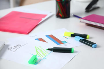 Closeup of white desktop with notepads, pen and other items. Selective focus.