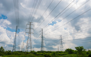 High voltage powerlines tower with cloudy and blue sky in background