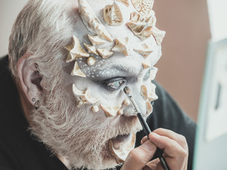 Actor applying make up on face