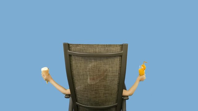 Young caucasian girl sitting on chair, drinking orange juice cocktail straw and eating ice cream.