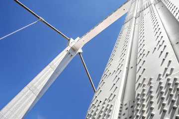 Metal pillars of cable bridge against blue sky - 165596832
