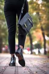 Girl in shoes with bag, walking along the street