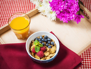 Multigrain wholewheat healthy cereals with fresh berry and a glass of juice for breakfast