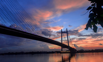 Silhouette of Vidyasagar Setu bridge at twilight .