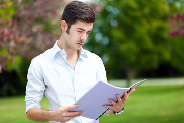 Fototapeta premium Male student reading outdoor