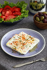 formaggio bianco con spezie pomodori e olive su tavolo grigio