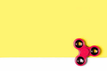 Fidget spinner background template with copy space. Popular kids stress and anxiety relief toy in the bottom right corner.
