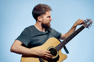 A man with a beard on a blue background holds a guitar, play, musical instruments, music, strings