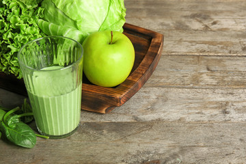 Glass of fresh juice on wooden background