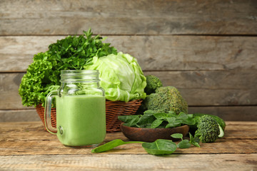 Mason jar of fresh juice on wooden background