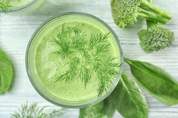 Glass of fresh vegetable juice on wooden background