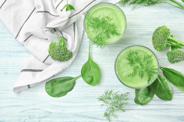 Glasses of fresh vegetable juice on wooden background