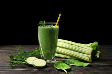 Glass of fresh vegetable juice on dark wooden table