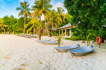 Beach chairs in Maldives island at the sunrise time .