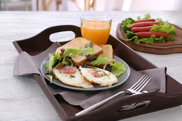 Composition with homemade tasty breakfast with fried eggs on wooden tray