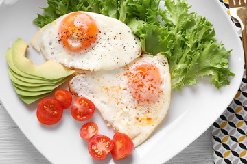 Delicious breakfast with fried eggs on white wooden table