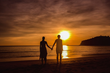 A couple holding hands during an amazing sunset. Loving couple in the pond at sunset hug