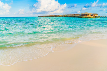 Beautiful water villas in tropical Maldives island at the sunrise time .