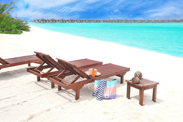 Wooden sun loungers with beach accessories at sea resort