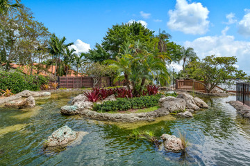Fototapeta na wymiar View looking at pond with tropical-inspired landscaping. 