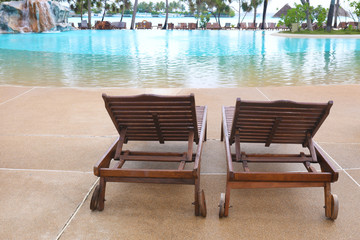 Wooden sun loungers near pool at sea resort
