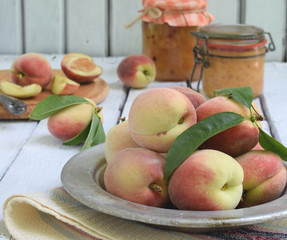 Bio organic peaches on a metal dish on a light background. Copy space