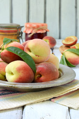 Bio organic peaches on a metal dish on a light background. Copy space