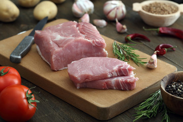 carne cruda di porco o maiale su sfondo tavolo di cucina rustico