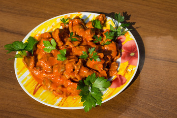 Chicken gizzard stew in plate on rustic wooden table