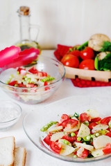 Tasty and healthy breakfast, lunch or dinner, potato salad with tomato, green peas, olive oil, spices and white toast on a light background 