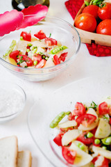 Tasty and healthy breakfast, lunch or dinner, potato salad with tomato, green peas, olive oil, spices and white toast on a light background 